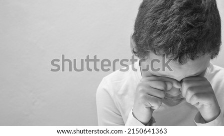 boy crying with hand over face crying alone and all by himself with white background with people stock photo 