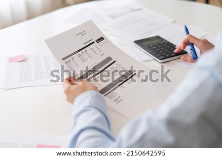 Cropped view of person making calculations and holding documents. Utility bills payment process. Accountant occupation. Remote job concept. Making financial report when working from home Royalty-Free Stock Photo #2150642595