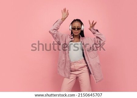 Romantic vibe. Monochrome portrait of young happy girl dancing and listening to music on pink background. Concept of beauty, art, fashion, youth, sales and ads. Looks happy, delighted. Copy space for