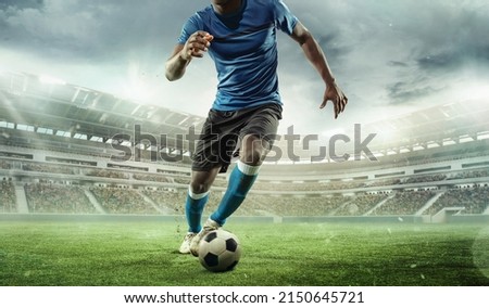 Cropped image of running soccer, football player at stadium during football match. Concept of sport, competition, goals. Collage, poster for ads. Crowded stadium effect Royalty-Free Stock Photo #2150645721