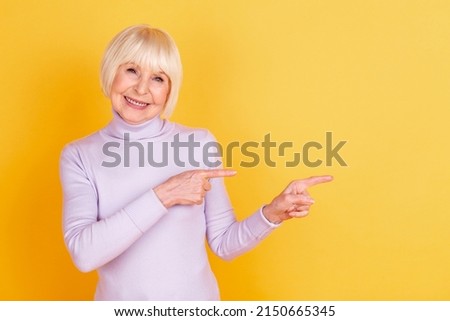Photo of attractive pretty woman indicate fingers empty space advertise choice isolated over yellow color background