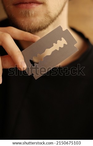 man's hand holding empty business card in the form of a blade for beauty salon, barbershop. stylish free blank copy space. . High quality photo