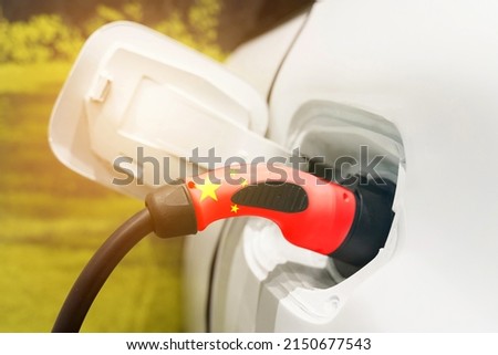 The concept of ecological transport. Charging electric vehicles with an electric cable with a picture of the flag of China