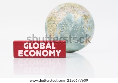 Business concept. Near the globe is a red plaque with the inscription - global economy