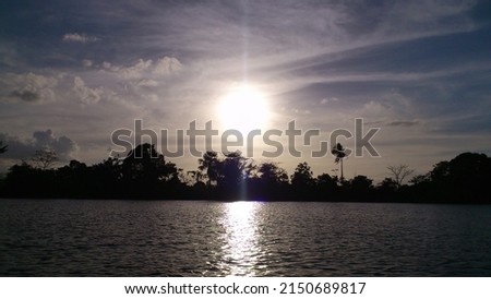 Sunset on Orinoco Delta river with tropic rain forest silhouette.