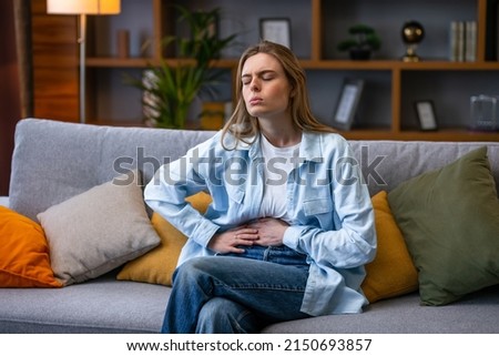 Woman hand in stomach ache, suffer from food poisoning, abdominal pain and colon problem, gastritis. Patient belly, abdomen or inflammation, concept. Royalty-Free Stock Photo #2150693857