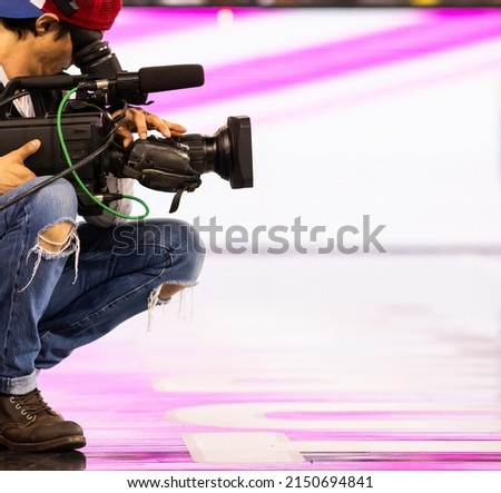 cameraman filming an event focus on camera