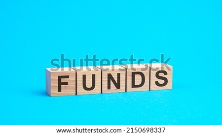funds - word is written on wooden cubes close-up. bright blue background, financial business concept, blue background