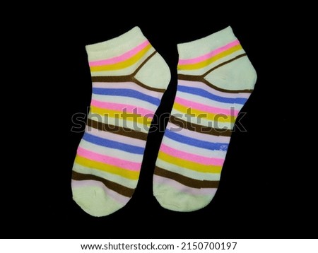 Socks with rainbow print. A pair of colorful socks on a black background.