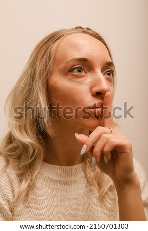 A young woman covering her mouth with her finger calls for silence Royalty-Free Stock Photo #2150701803