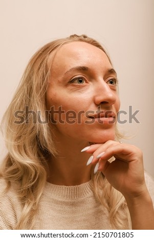 A young woman leaning on her hand smiles Royalty-Free Stock Photo #2150701805