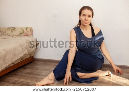 woman sitting in yoga pose and meditating at home