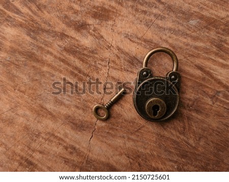 Vintage bronze key and padlock on wooden background with copy and text space.