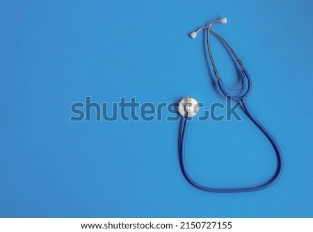 Medical stethoscope lies on a blue background. The medicine. Soft focus