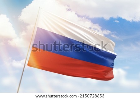 Sunny blue sky and a flagpole with the flag of russia