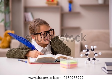 Young little girl studying at home Royalty-Free Stock Photo #2150733777