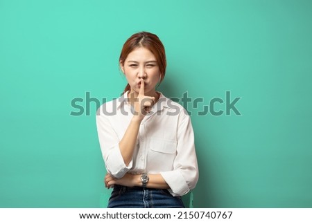 Angry business woman, boss shushing, show taboo hush gesture and frowning, be quiet, scolding loud people on meeting, standing angry against green background.