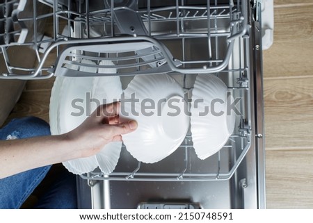 clean dishes in the dishwasher basket. Cleaning the house and washing dishes in the dishwasher.
