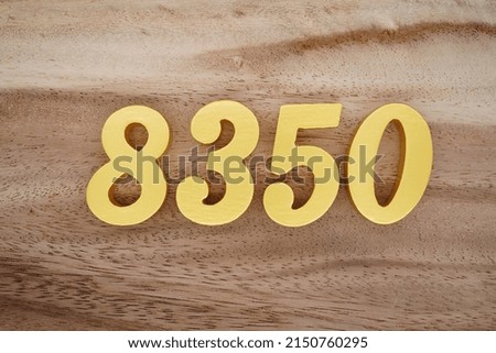 Wooden  numerals 8350 painted in gold on a dark brown and white patterned plank background.