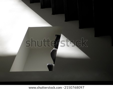 Multiple black and white photographs of stairs in a modern home with different lighting. 