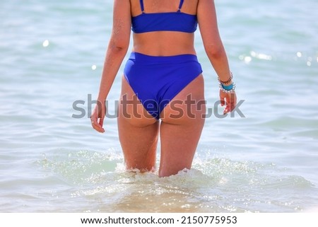 Girl in a swimsuit on the beach near the sea.