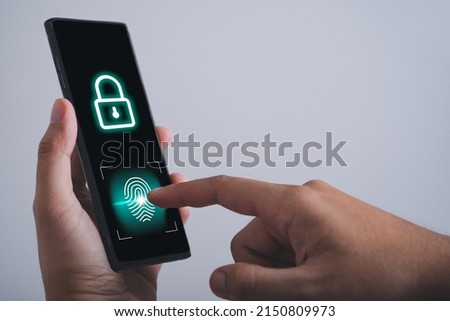 man hand hold smartphone, tablet, cell phone with lock icon on screen and scan finger print on mobile phone. Lock screen data technology concept.  Royalty-Free Stock Photo #2150809973