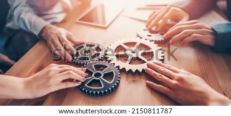 Group of people working in the office while putting together cogwheels. Concept of teamwork and togetherness. Royalty-Free Stock Photo #2150811787