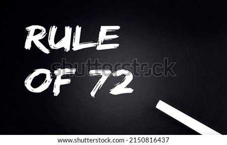 RULE OF 72 Text on a Black Chalkboard with a piece of chalk Royalty-Free Stock Photo #2150816437
