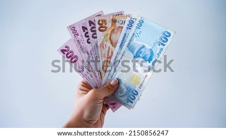 A hand holds Turkish Lira Banknotes with an isolated background                       Royalty-Free Stock Photo #2150856247