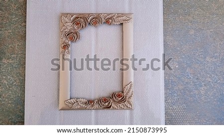 Old picture frame with beautiful floral borders in a white and pattern background. 