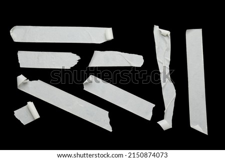 Many pieces of masking adhesive tape on black background, flat lay