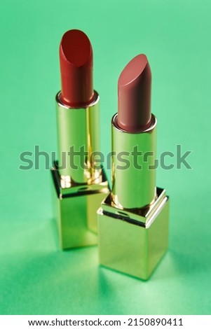 lipstick in different shades of red and pink colors on a green background.