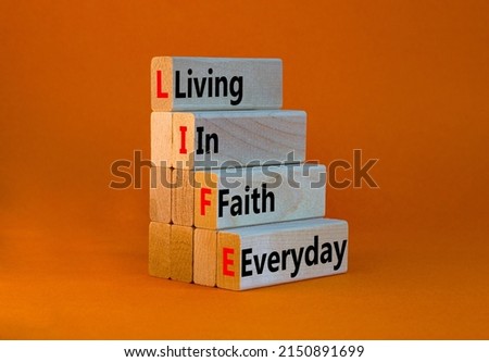 LIFE living in faith everyday symbol. Concept words LIFE living in faith everyday on wooden blocks beautiful orange table orange background. Business LIFE living in faith everyday concept. Copy space.