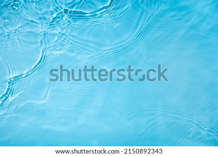 Transparent blue clear water surface texture with ripples, splashes and bubbles. Abstract nature background Water waves in sunlight. Cosmetic moisturizer micellar toner emulsion. Top view, copy space Royalty-Free Stock Photo #2150892343