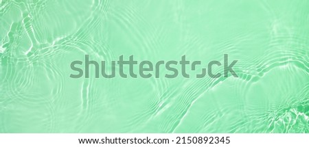 Abstract summer banner background Transparent green clear water surface texture with ripples and splashes. Water wave in sunlight, copy space, top view Cosmetics moisturizer micellar toner emulsion Royalty-Free Stock Photo #2150892345