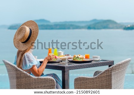 Unrecognizable woman on luxury lifestyle vacation holiday travel eating breakfast with sea paradise view. Side view of travel girl at Thailand resort in natural landscape. Summer tropical vacation. Royalty-Free Stock Photo #2150892601