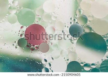Green red and yellow light tones oil with water round different sizes bubbles macro