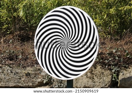 Optical illusion spiral wheel with a natural background Royalty-Free Stock Photo #2150909619