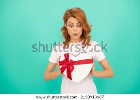 surprised woman hold heart present box on blue background