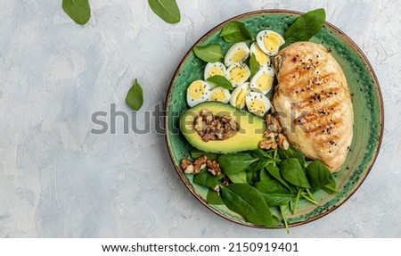Chicken fillet with salad. Buddha Bowl on a dark background. Healthy food, keto diet, Healthy fats, clean eating for weight loss, banner, menu, recipe place for text, top view. Royalty-Free Stock Photo #2150919401