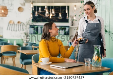 woman paying bill contactless with debit card Royalty-Free Stock Photo #2150929627