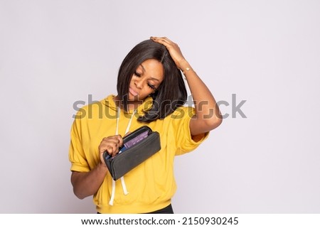 broke african lady holding her empty wallet Royalty-Free Stock Photo #2150930245