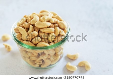roasted cashew nut in glass bowl on white table background.