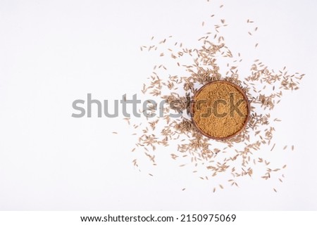 cumin seeds and cumin ground, powder. Pile of cumin powder isolated in a rock bowl on white background. Heap of ground caraway. Selective focus. Top view. blank space
