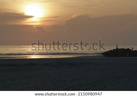 Fishermen on the rocks against the sunrise