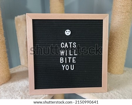 A closeup of a sign that says cat will bite you.