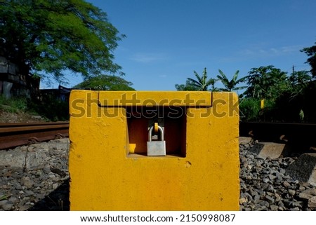 padlock on a yellow square with a blue sky background