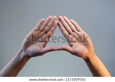 hand gesture, triangle shape, male doing triangle hand gesture on toned background, isolated. illuminati Royalty-Free Stock Photo #2151009561