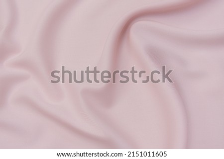 Close-up texture of natural red or pink fabric or cloth in same color. Fabric texture of natural cotton, silk or wool, or linen textile material. Red and orange canvas background. Royalty-Free Stock Photo #2151011605