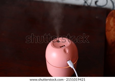 pink air humidifier on brown table